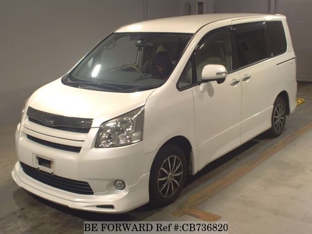 A grey JDM sports car speeding down a highway at night.