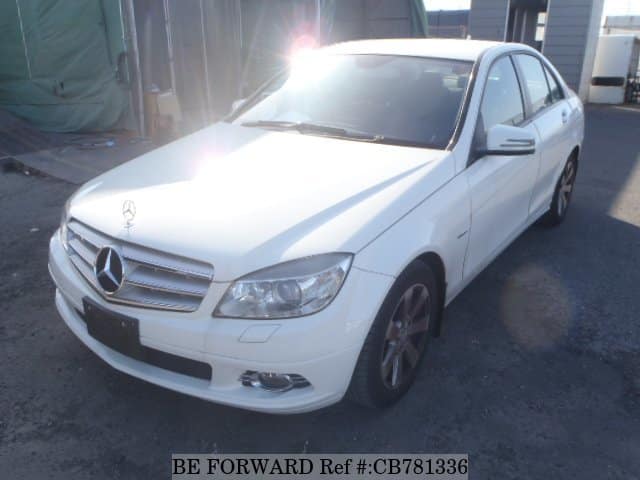 A grey sports car speeding down a highway at night.