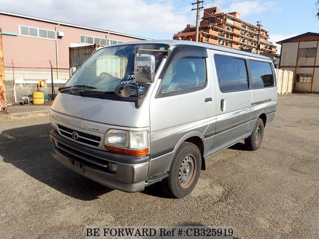 A grey JDM sports car speeding down a highway at night.