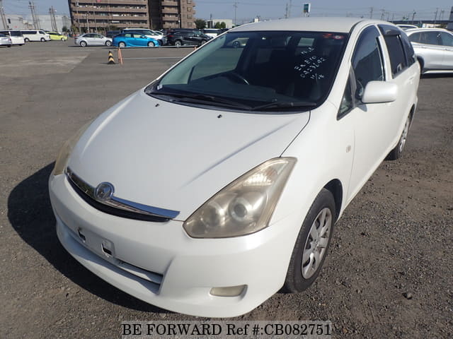 A grey JDM sports car speeding down a highway at night.