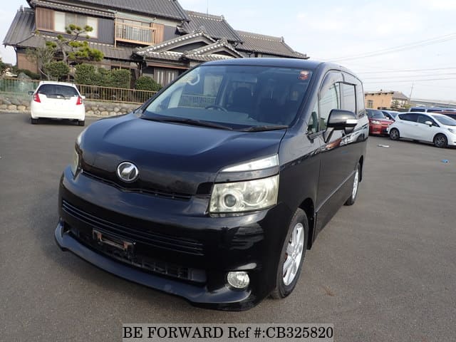 A grey JDM sports car speeding down a highway at night.