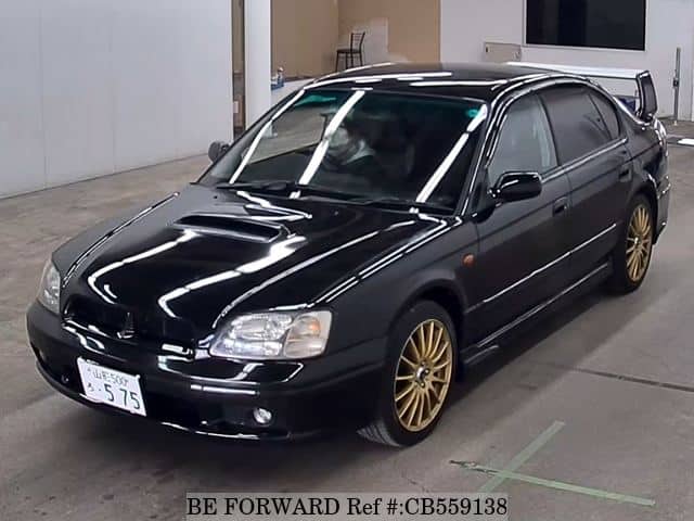 A grey JDM sports car speeding down a highway at night.