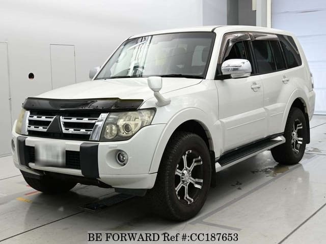 A grey sports car speeding down a highway at night.