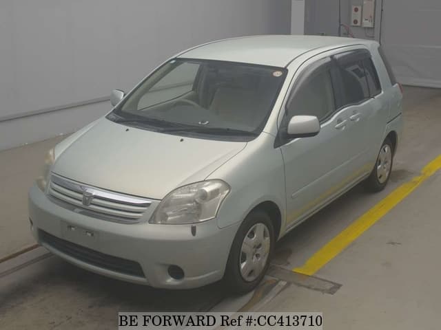 A grey sports car speeding down a highway at night.