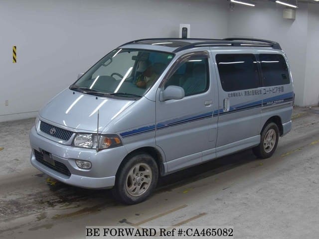 A grey JDM sports car speeding down a highway at night.