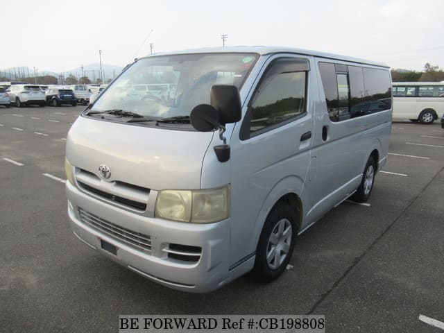 A grey sports car speeding down a highway at night.
