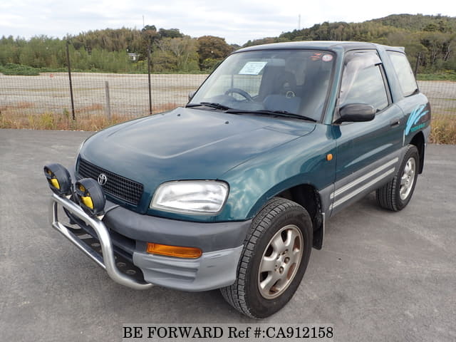 A grey JDM sports car speeding down a highway at night.