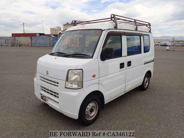 A grey sports car speeding down a highway at night.