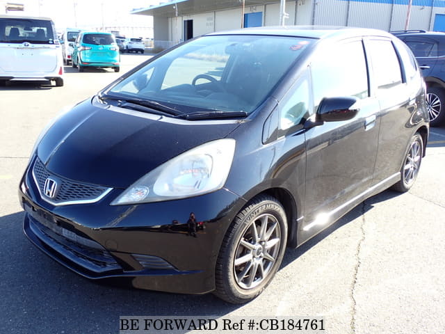 A grey JDM sports car speeding down a highway at night.