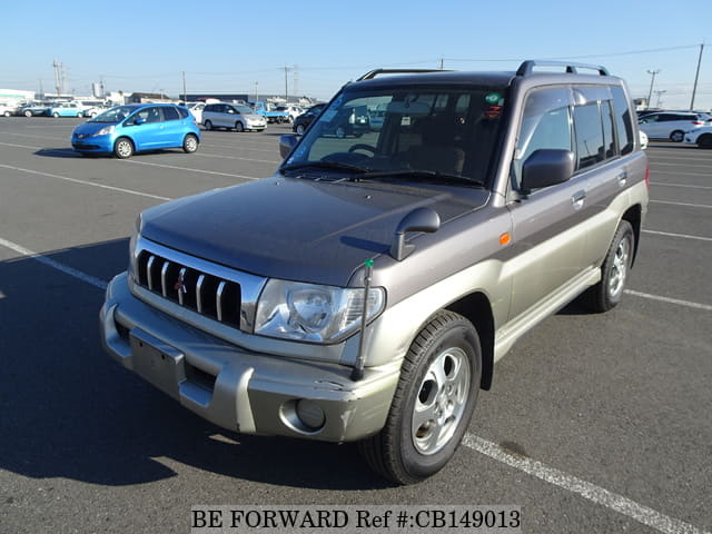 A grey sports car speeding down a highway at night.