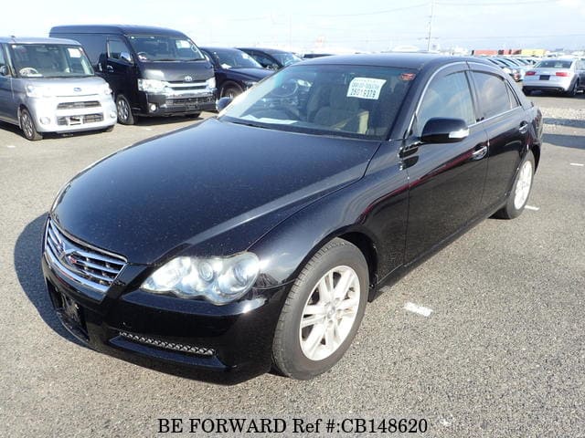 A grey JDM sports car speeding down a highway at night.