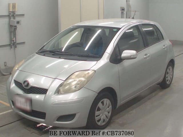 A grey JDM sports car speeding down a highway at night.