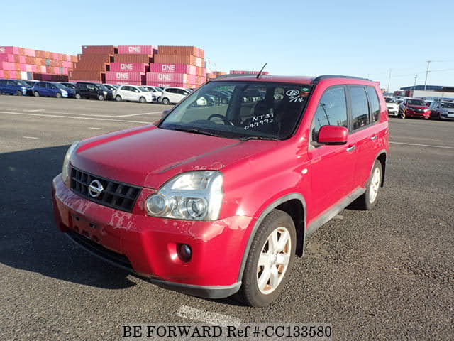 A grey sports car speeding down a highway at night.