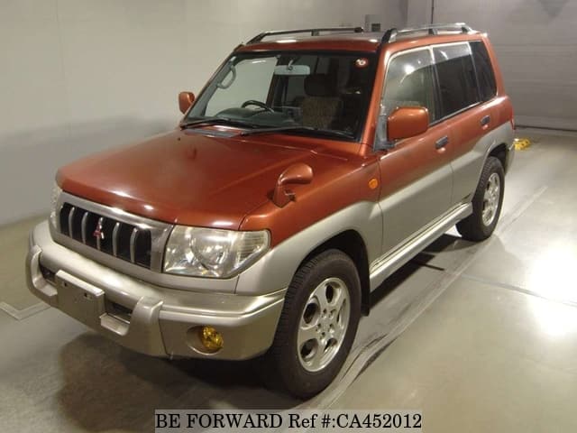 A grey JDM sports car speeding down a highway at night.