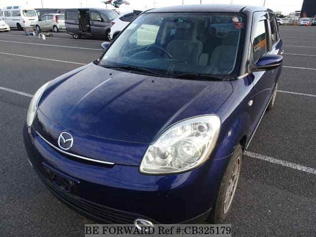 A grey JDM sports car speeding down a highway at night.