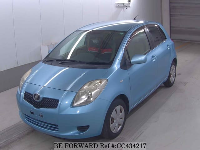 A grey sports car speeding down a highway at night.
