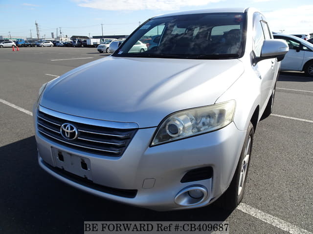 A grey JDM sports car speeding down a highway at night.