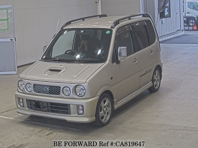 A grey JDM sports car speeding down a highway at night.