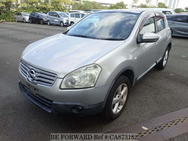 A grey JDM sports car speeding down a highway at night.