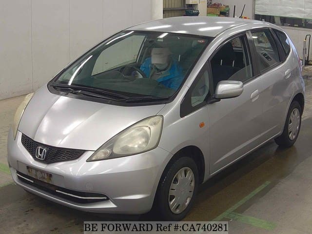 A grey JDM sports car speeding down a highway at night.