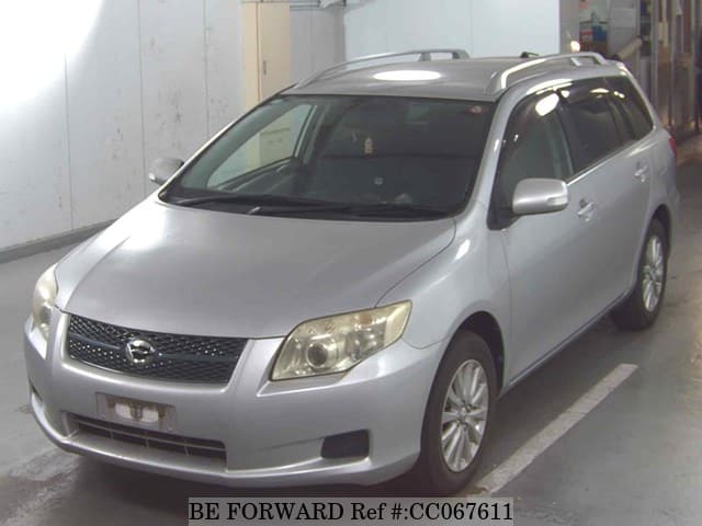 A grey sports car speeding down a highway at night.