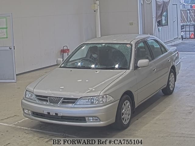 A grey JDM sports car speeding down a highway at night.