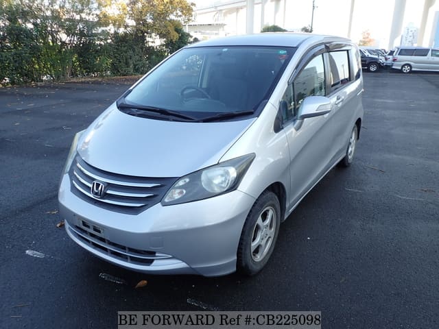 A grey JDM sports car speeding down a highway at night.