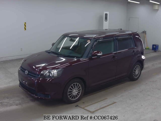 A grey sports car speeding down a highway at night.
