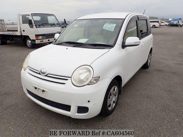 A grey JDM sports car speeding down a highway at night.