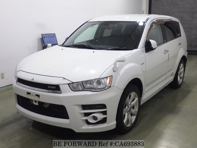 A grey JDM sports car speeding down a highway at night.