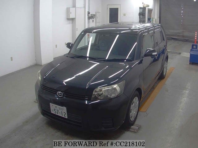 A grey sports car speeding down a highway at night.