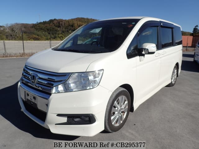 A grey JDM sports car speeding down a highway at night.