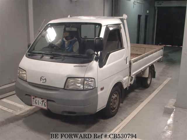A grey JDM sports car speeding down a highway at night.