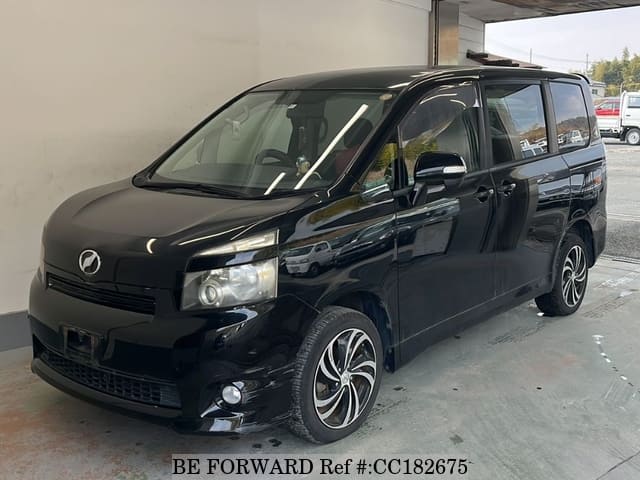 A grey sports car speeding down a highway at night.