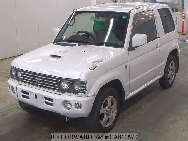 A grey JDM sports car speeding down a highway at night.