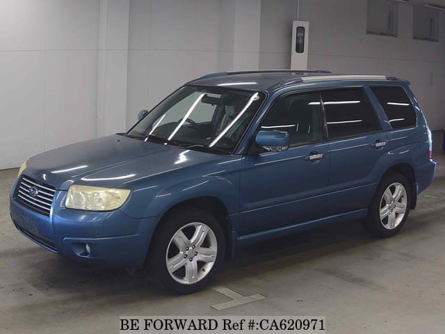 A grey JDM sports car speeding down a highway at night.