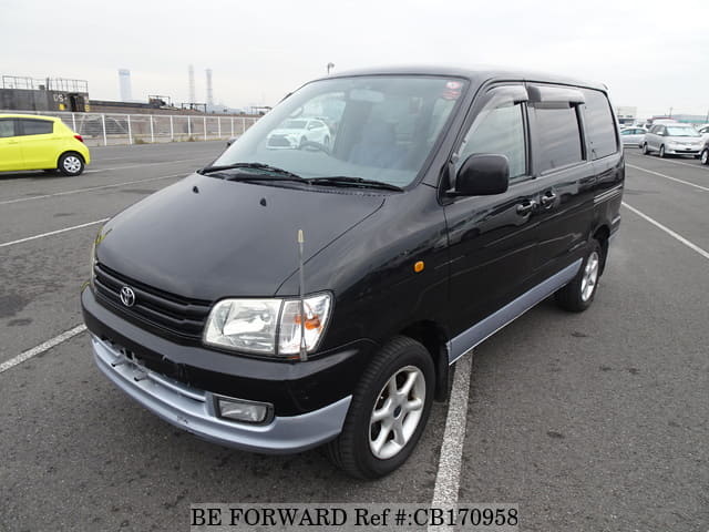 A grey JDM sports car speeding down a highway at night.