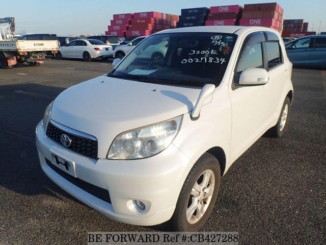 A grey JDM sports car speeding down a highway at night.
