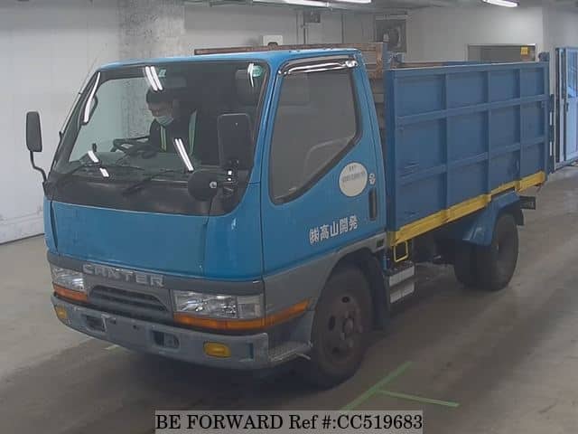 A grey sports car speeding down a highway at night.