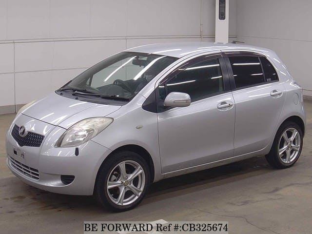 A grey JDM sports car speeding down a highway at night.