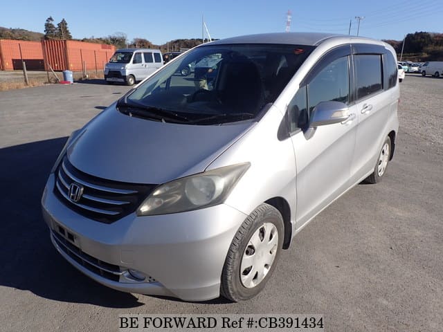 A grey JDM sports car speeding down a highway at night.