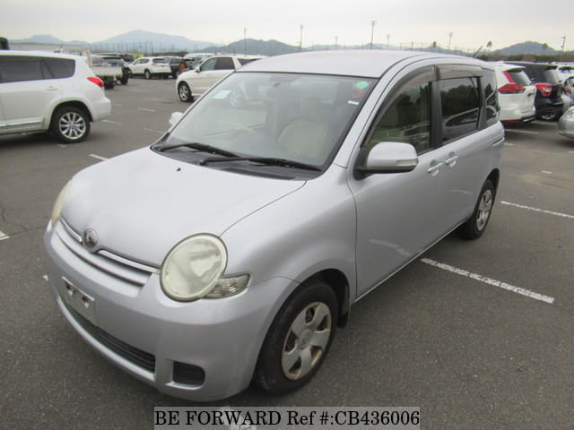 A grey sports car speeding down a highway at night.