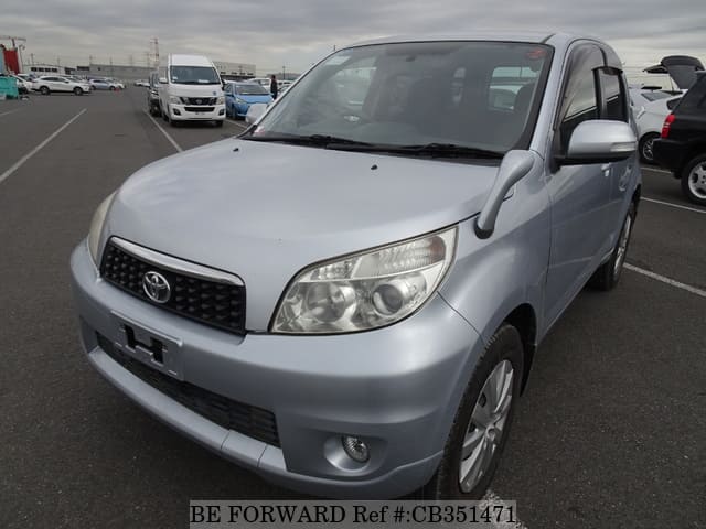 A grey JDM sports car speeding down a highway at night.