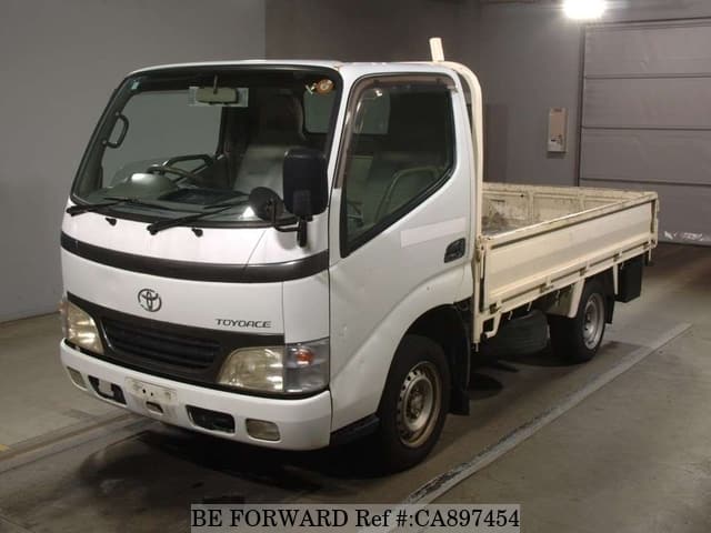 A grey JDM sports car speeding down a highway at night.