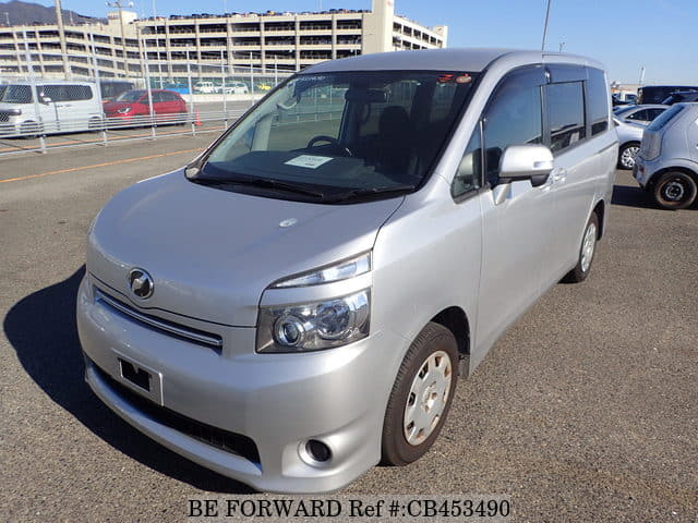 A grey JDM sports car speeding down a highway at night.