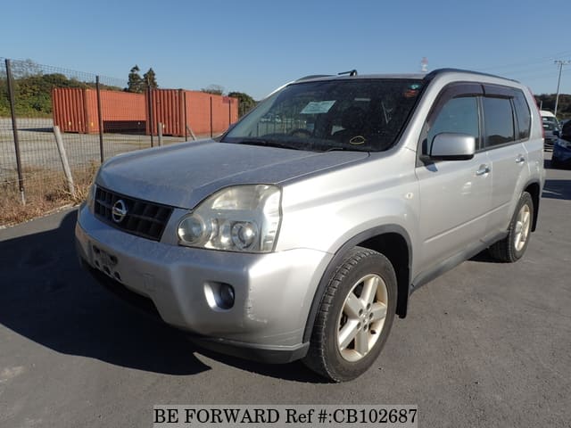A grey sports car speeding down a highway at night.