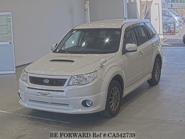 A grey JDM sports car speeding down a highway at night.