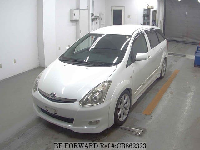 A grey JDM sports car speeding down a highway at night.
