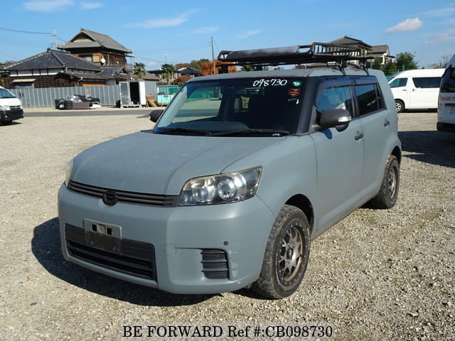 A grey JDM sports car speeding down a highway at night.