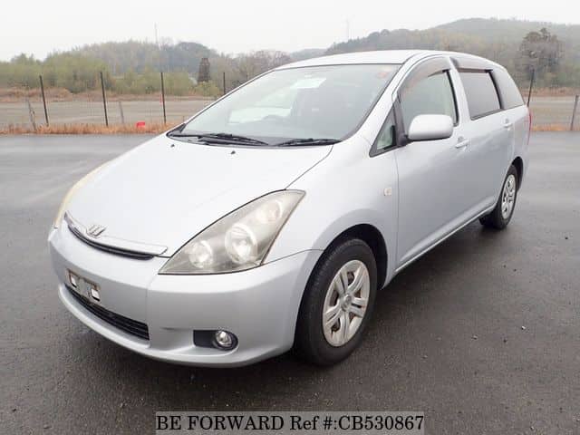 A grey JDM sports car speeding down a highway at night.